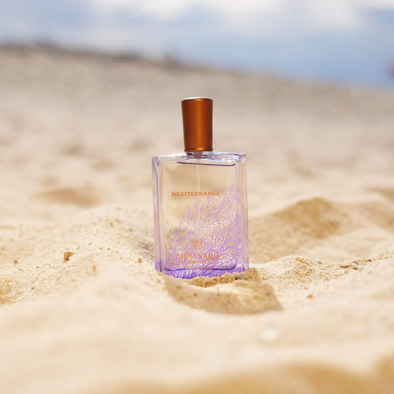 Perfume Méditerranée sobre arena en la playa