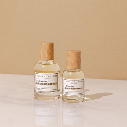 Perfume Coriandre & Bois de Cèdre de L'Essence des notes 2 botellas en base de marmol con fondo beige