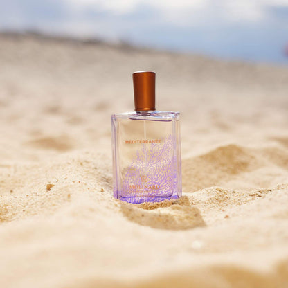 Perfume Méditerranée sobre arena en la playa