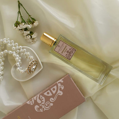 Perfume Songeries de Galimard formato de 100 junto a joyas sobre una tela de seda