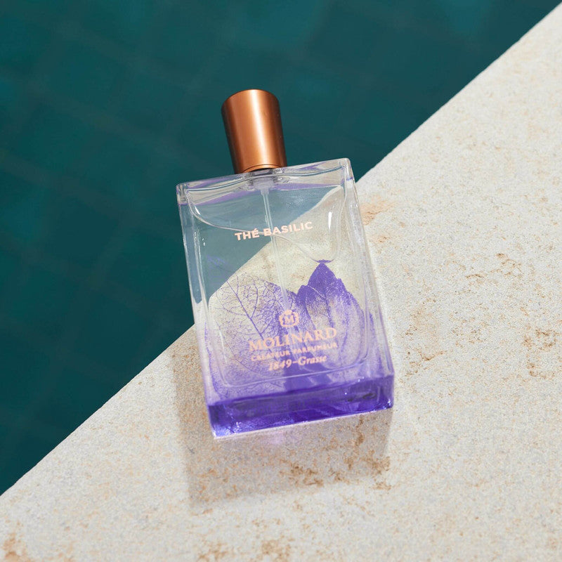 Perfume Thé Basilic sobre arena en la playa