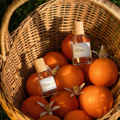 Perfume Fleur d'oranger de L'Essence des notes 2 botellas en canasto de naranjas con flores